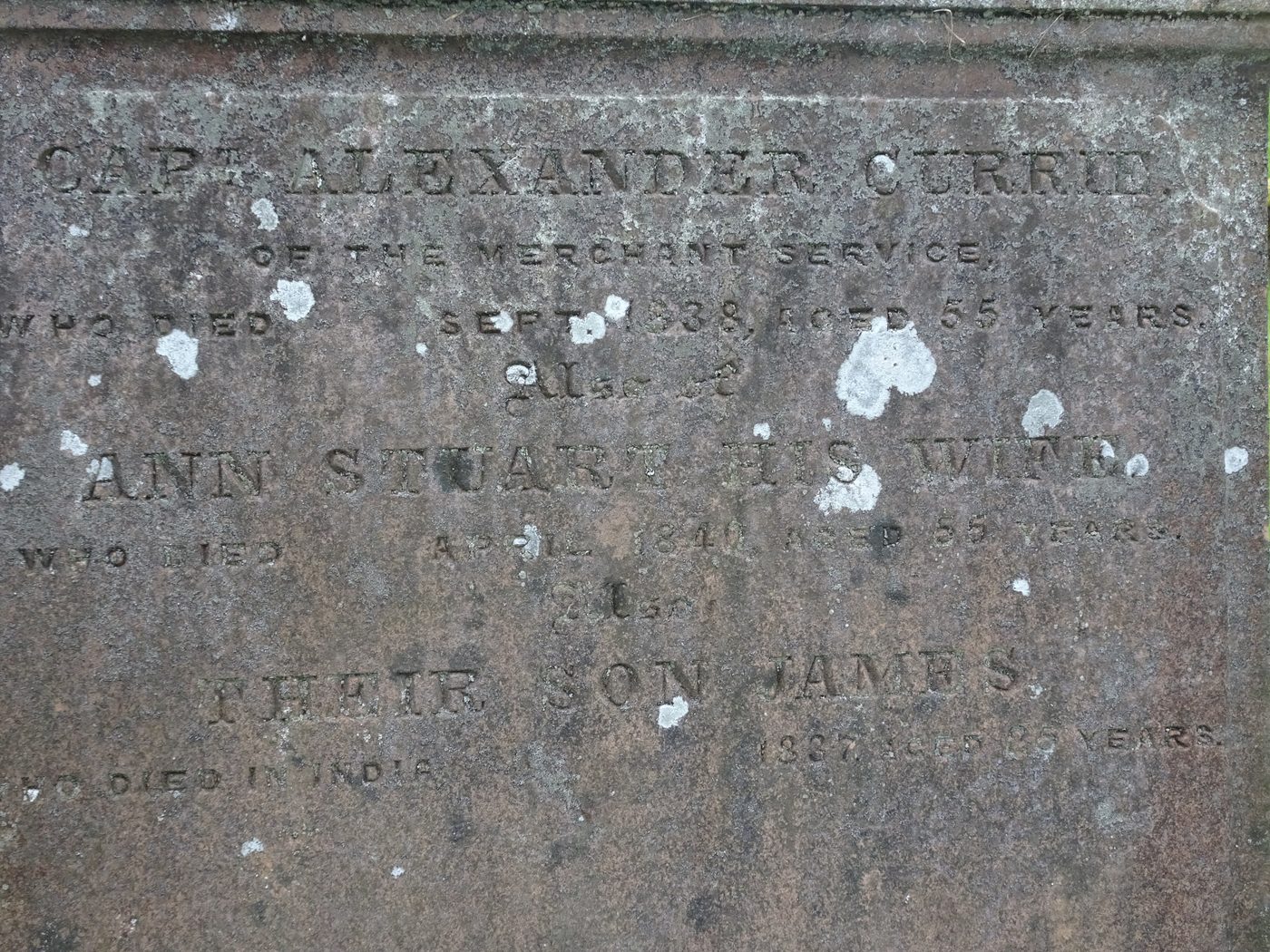 A dark, lichen-spotted stone panel: Capt. Alexander Currie of the Merchant Service, who died September 1838 aged 55 years; also Ann Stuart his wife, who died April 1840 aged 55 years; also their son James, who died in India 1837.